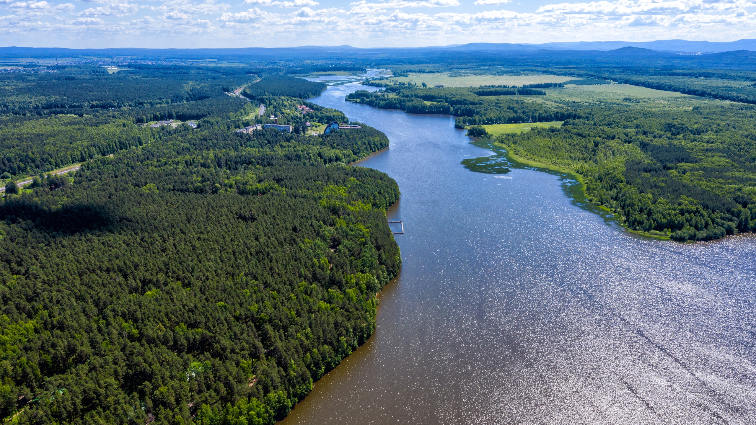 Aerial view of a river winding through dense forest